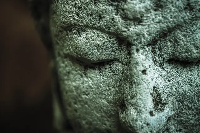 Rostro de piedra en calma, símbolo de la observación interior